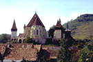 Vista exterior de la aldea, destacando de la niebla la iglesia-fortaleza.